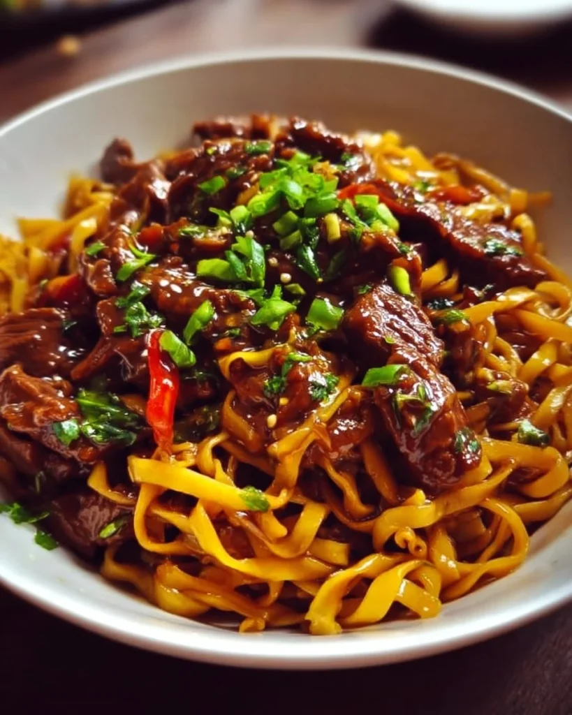Delicious sticky beef noodles garnished with fresh vegetables