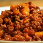 A bowl of hearty beef chili topped with cheese and cilantro.