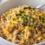 A flavorful plate of beef and rice garnished with vegetables.
