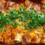 Plate of beef enchiladas topped with cheese and salsa