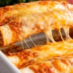 Delicious beef enchiladas with cheese and sauce on a plate