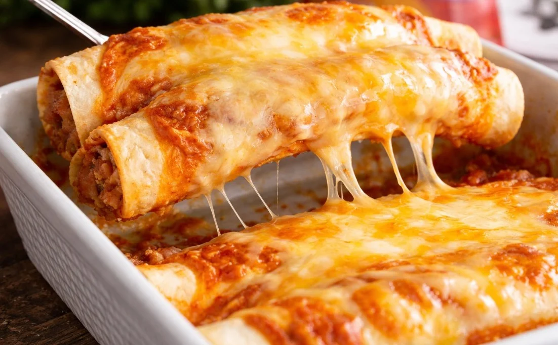 Delicious beef enchiladas with cheese and sauce on a plate