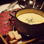 A delicious beef fondue served with fresh vegetables and sauces