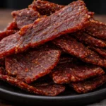 Savory beef jerky snacks in a rustic wooden bowl.