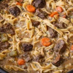 Delicious bowl of beef noodle soup with fresh herbs and noodles