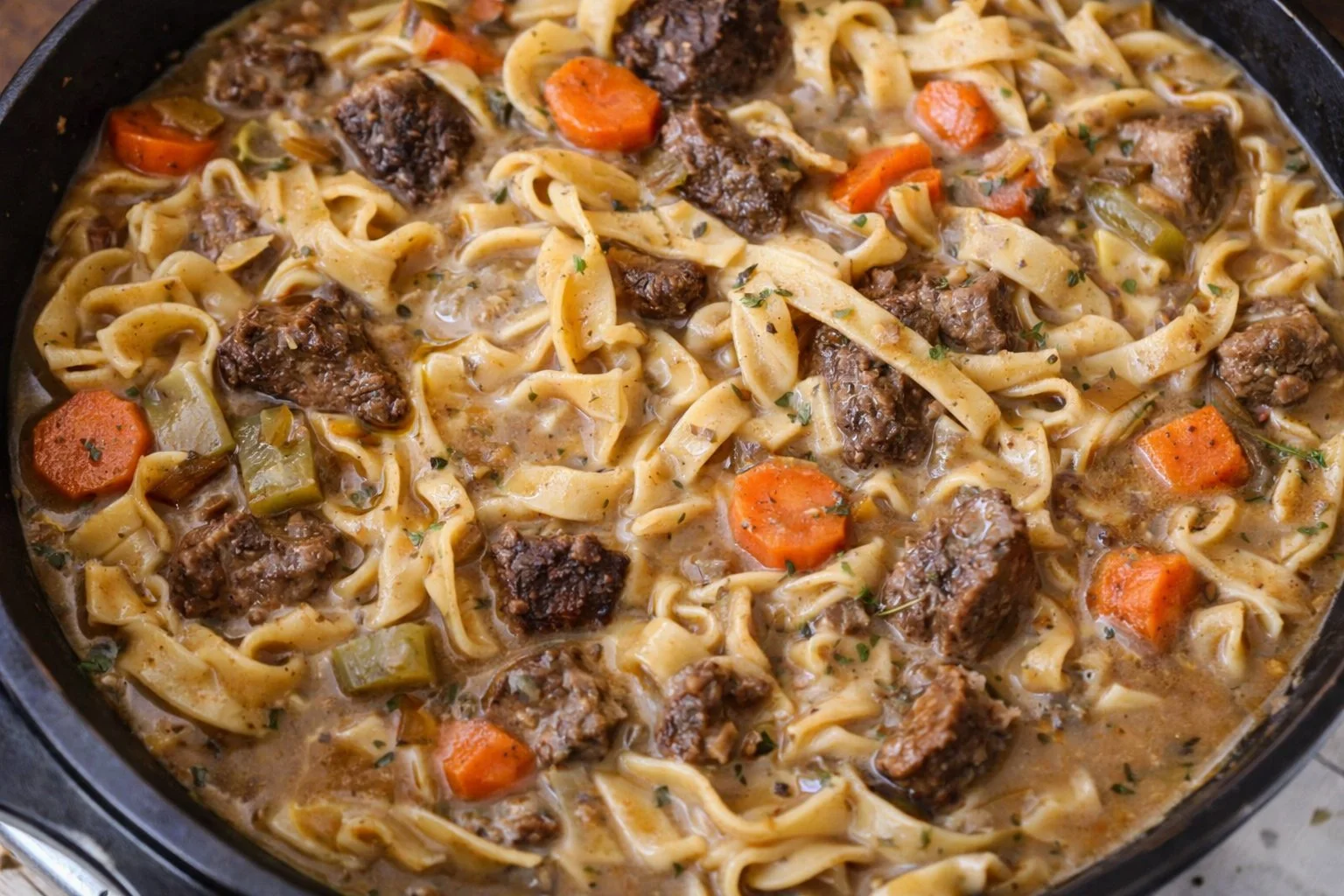 Delicious bowl of beef noodle soup with fresh herbs and noodles