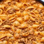 Creamy beef and shells in a bowl, garnished with parsley and served warm.