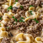 Delicious crock pot beef stroganoff served with egg noodles and garnished with parsley