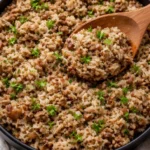 Plate of Dirty Rice with Ground Beef garnished with herbs