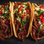 Delicious shredded beef tacos topped with fresh ingredients and served with lime wedges