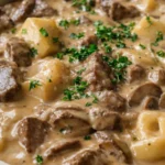 Delicious slow cooker beef stroganoff served with egg noodles and garnished with parsley.