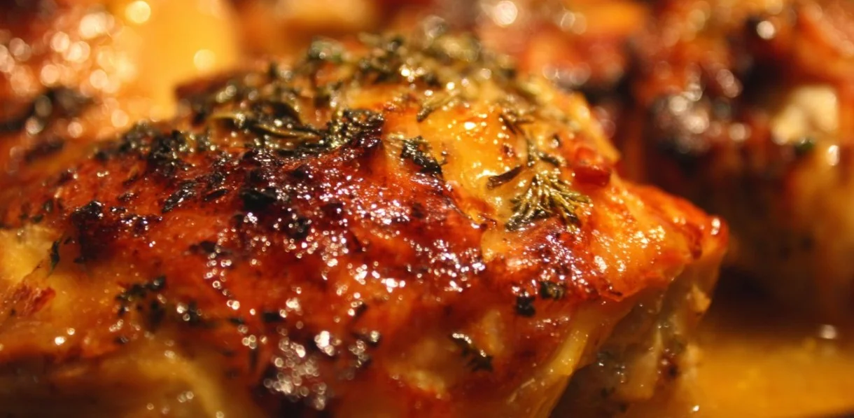 Plate of Alice Springs Chicken topped with cheese and bacon, served with sides.