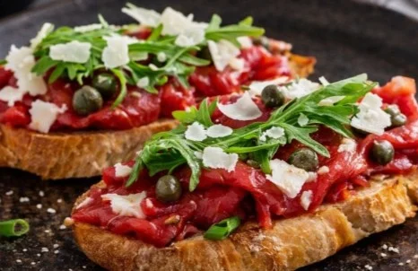 Delicious Beef Carpaccio with Parmesan and olive oil on a plate.