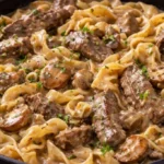 A bowl of savory beef noodles topped with herbs and spices