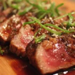 Sliced Beef Tataki garnished with herbs and served with dipping sauce