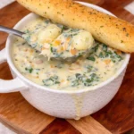 Bowl of creamy Chicken and Gnocchi Soup topped with herbs and spices