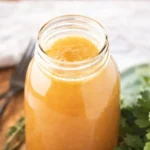 Homemade chicken broth simmering with vegetables and herbs