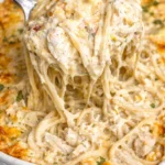 Creamy Chicken Tetrazzini dish topped with cheese and parsley on a plate