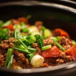 Crockpot ground beef recipe with fresh ingredients in a slow cooker