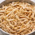 Crockpot dish featuring tender shredded chicken ready to serve