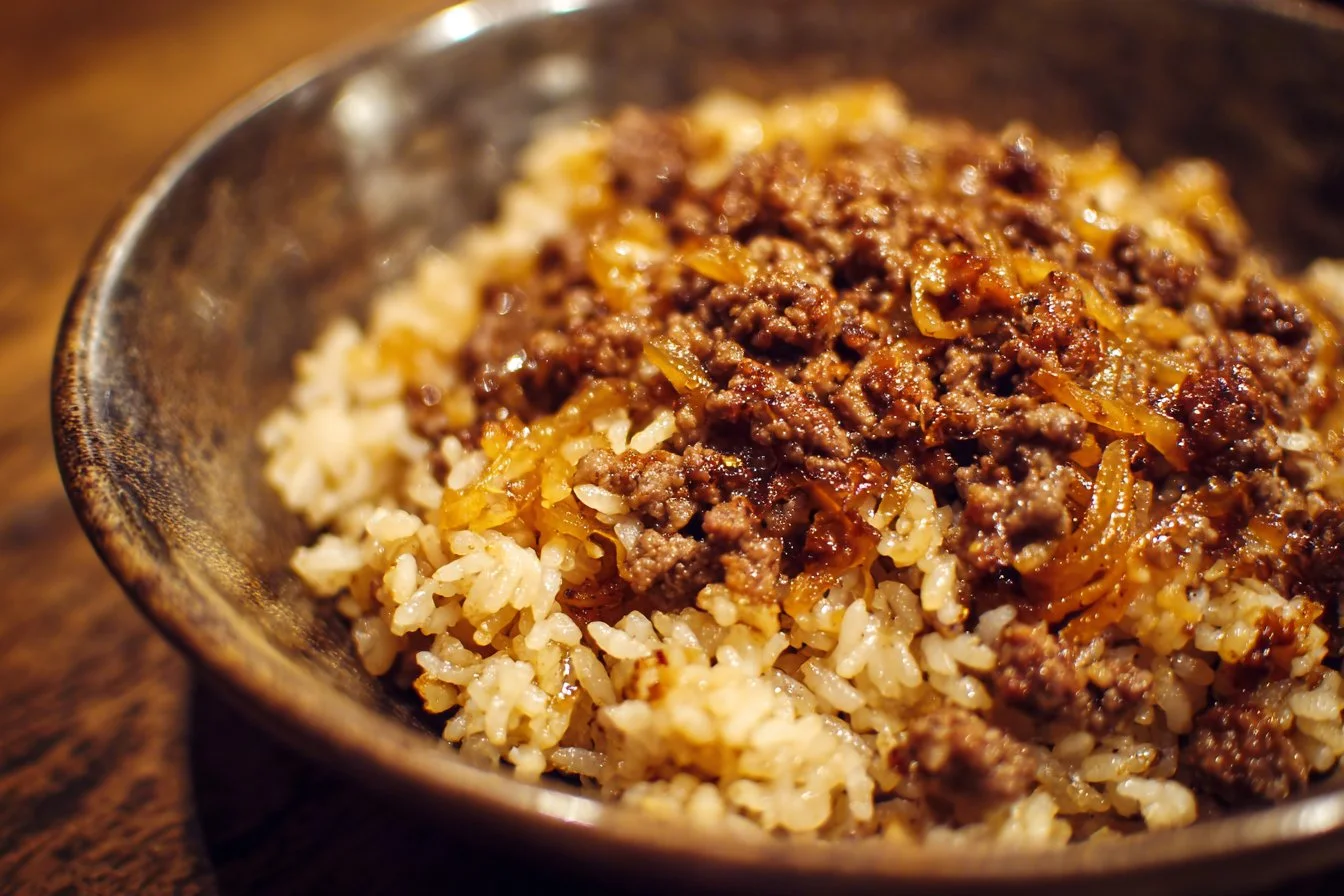 French onion ground beef and rice dish, garnished with cheese and herbs.