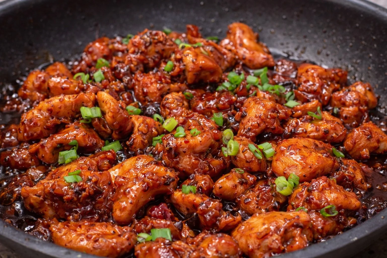 Plate of honey chicken garnished with herbs and served with rice.
