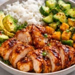 Delicious Hot Honey Chicken Bowl garnished with fresh vegetables and sauce