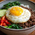 Korean Ground Beef Bowl with vegetables and rice topped with sesame seeds