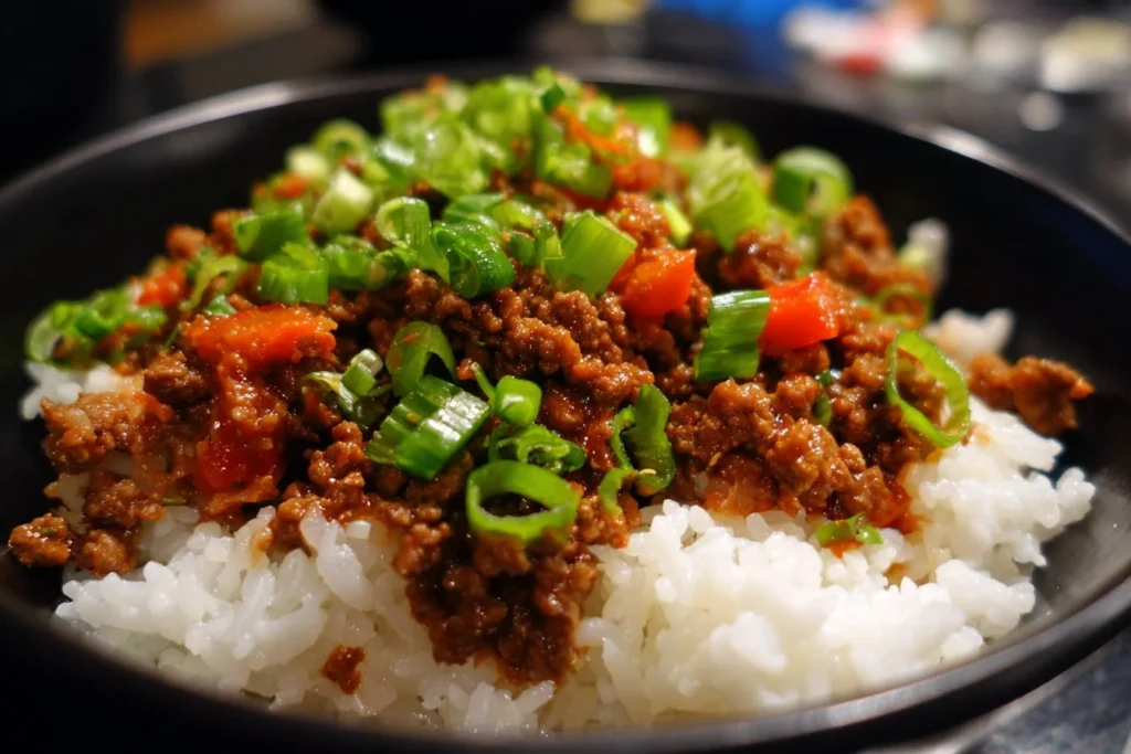 Plate of teriyaki ground beef served over rice with vegetables