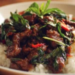 Delicious plate of Thai Basil Beef with savory beef and fresh basil leaves.