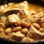 Bowl of creamy White Chili Chicken garnished with herbs