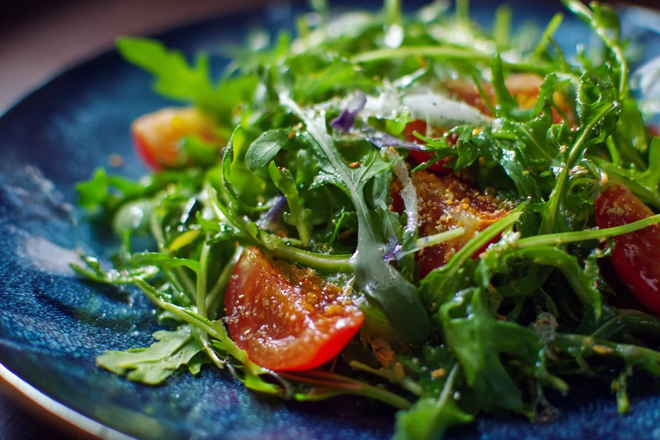 Fresh arugula salad with mixed vegetables and dressing