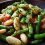 Colorful bean salad with fresh vegetables and herbs in a bowl.