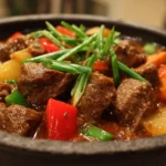 A hearty bowl of Beef Caldereta, a rich Filipino beef stew with vegetables.