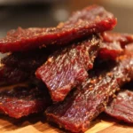 Homemade beef jerky marinating in a savory blend of spices and seasonings.