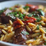 A delicious dish of Beef Orzo served in a bowl with herbs and spices.