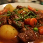 Bowl of delicious beef stew with vegetables and herbs, perfect for a comforting meal.