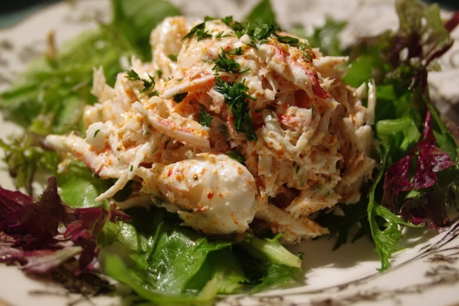 Fresh crab salad with vegetables and dressing served in a bowl