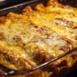 Easy beef enchiladas topped with cheese and served on a plate