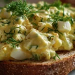 Delicious homemade egg salad served in a bowl with fresh herbs.