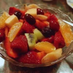 Colorful fruit salad with strawberries, blueberries, and tropical fruits in a bowl.