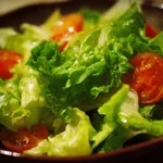 A colorful bowl of fresh green salad with vegetables and dressing