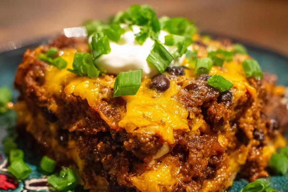 Delicious ground beef enchilada casserole topped with cheese and fresh herbs