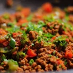 A delicious homemade ground beef recipe on a plate with fresh herbs