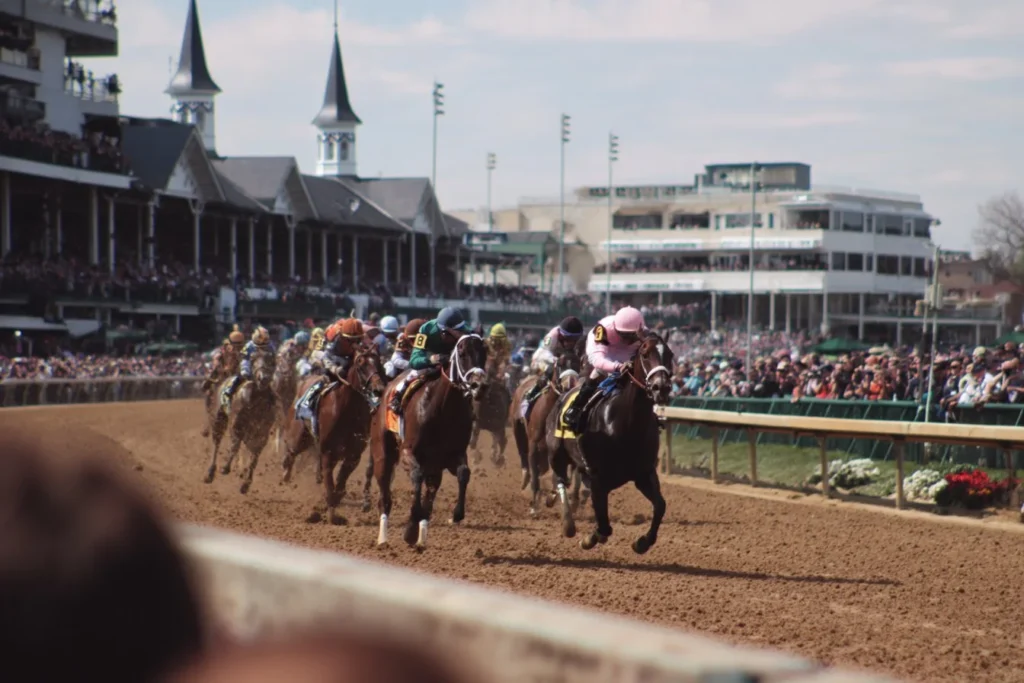 Exciting scene at the Kentucky Derby with horses racing and enthusiastic crowd.