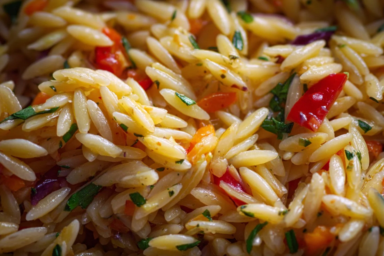 Colorful orzo pasta salad with fresh vegetables and herbs in a bowl
