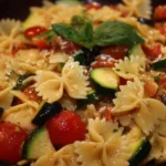 A colorful and fresh pasta salad with vegetables and dressing in a bowl