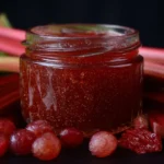 Homemade rhubarb jam jar with fresh rhubarb stalks.