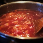 Homemade rhubarb sauce in a jar with fresh rhubarb stalks