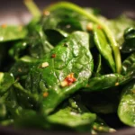 Fresh spinach salad with colorful vegetables and dressing